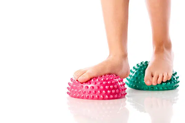 Little girl performing flat feet exercises, isolated on white background