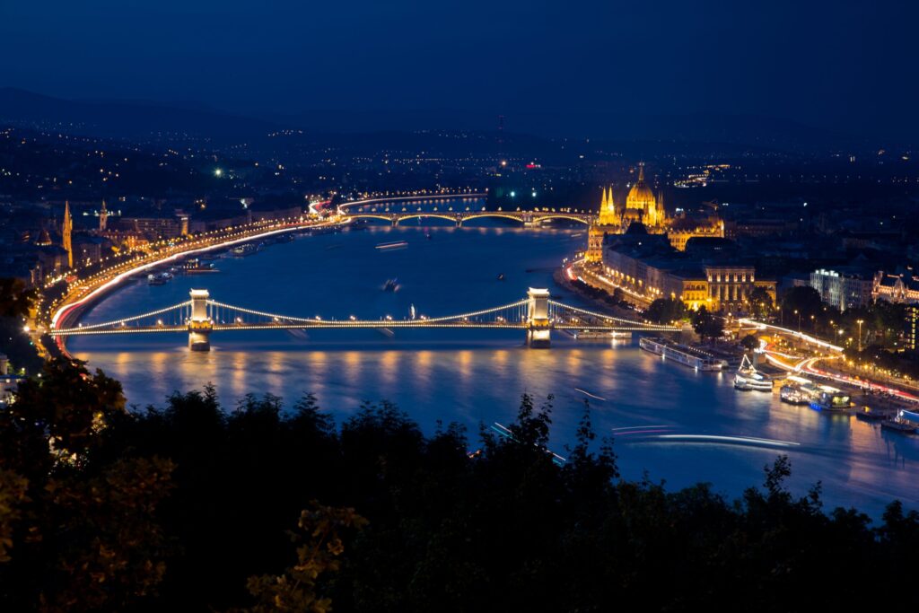 Buda castle surrounded by buildings and lights during the night in budapest