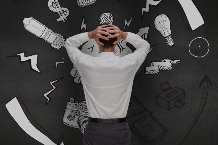 Rear view of a confused man looking at graphics on black wall
