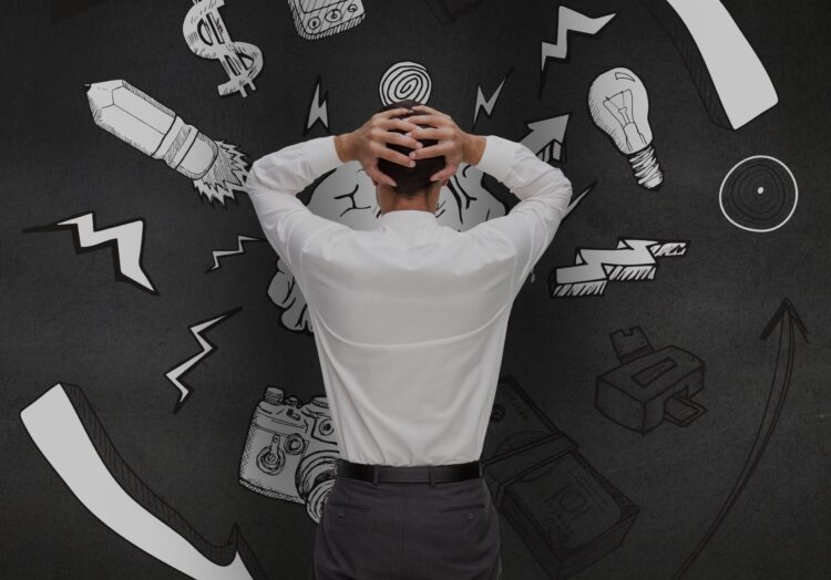Rear view of a confused man looking at graphics on black wall