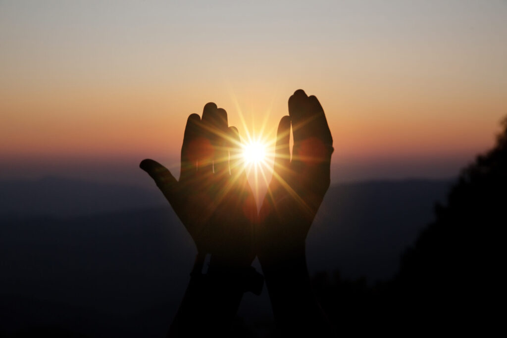 Faith of christian concept: spiritual prayer hands over sun shin